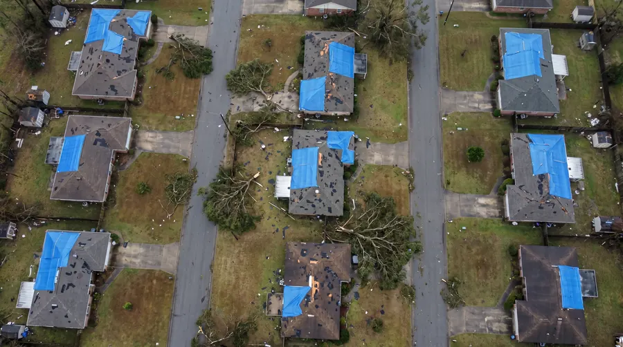 Aerial view of a Gulf Coast neighbourhood with blue tarps on damaged roofs